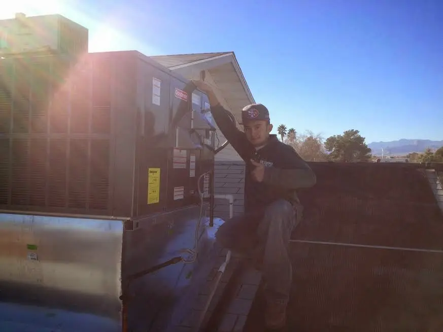 HVAC technician performing Air Duct Repair on a rooftop unit in Montrose